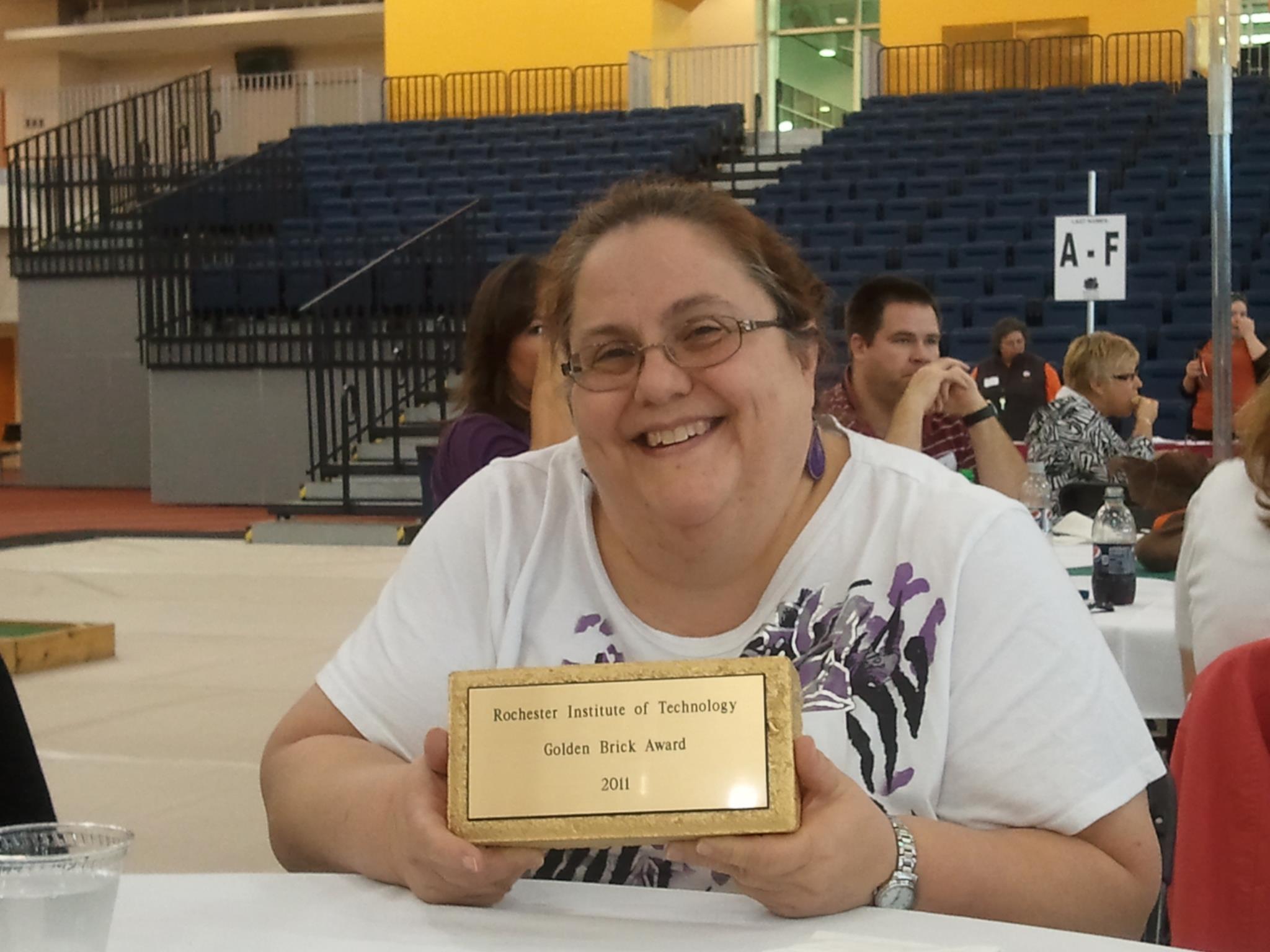Debbie Kingsbury Holding Golden Brick Award from 2011